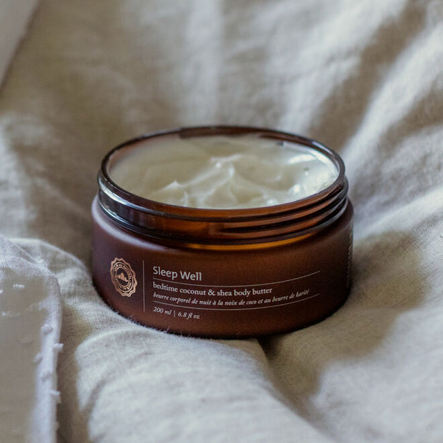 Sleep Well body butter container on beige bedding